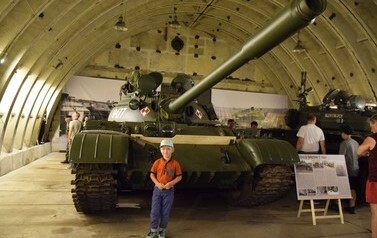 zdjęcie czołgu w hangarze, chłopiec przed czołgiem