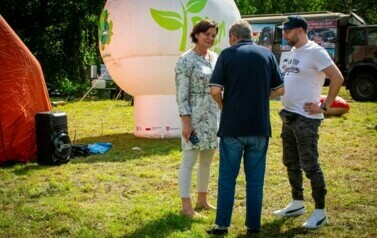 Trzy osoby rozmawiają na dworze - 1. kobieta i 2. mężczyzn.
