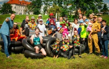 Zdjęcie grupowe, ludzie w kolorowych przebraniach, obok dętki.