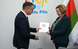 Mężczyzna wręcza kobiecie teczkę z logotypem Miasto Piła