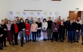 grupa ludzi przed banerem 