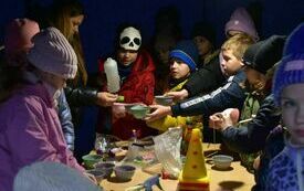 Grupa dzieci w namiocie przy stole przy kt&oacute;rym robią eksperymenty