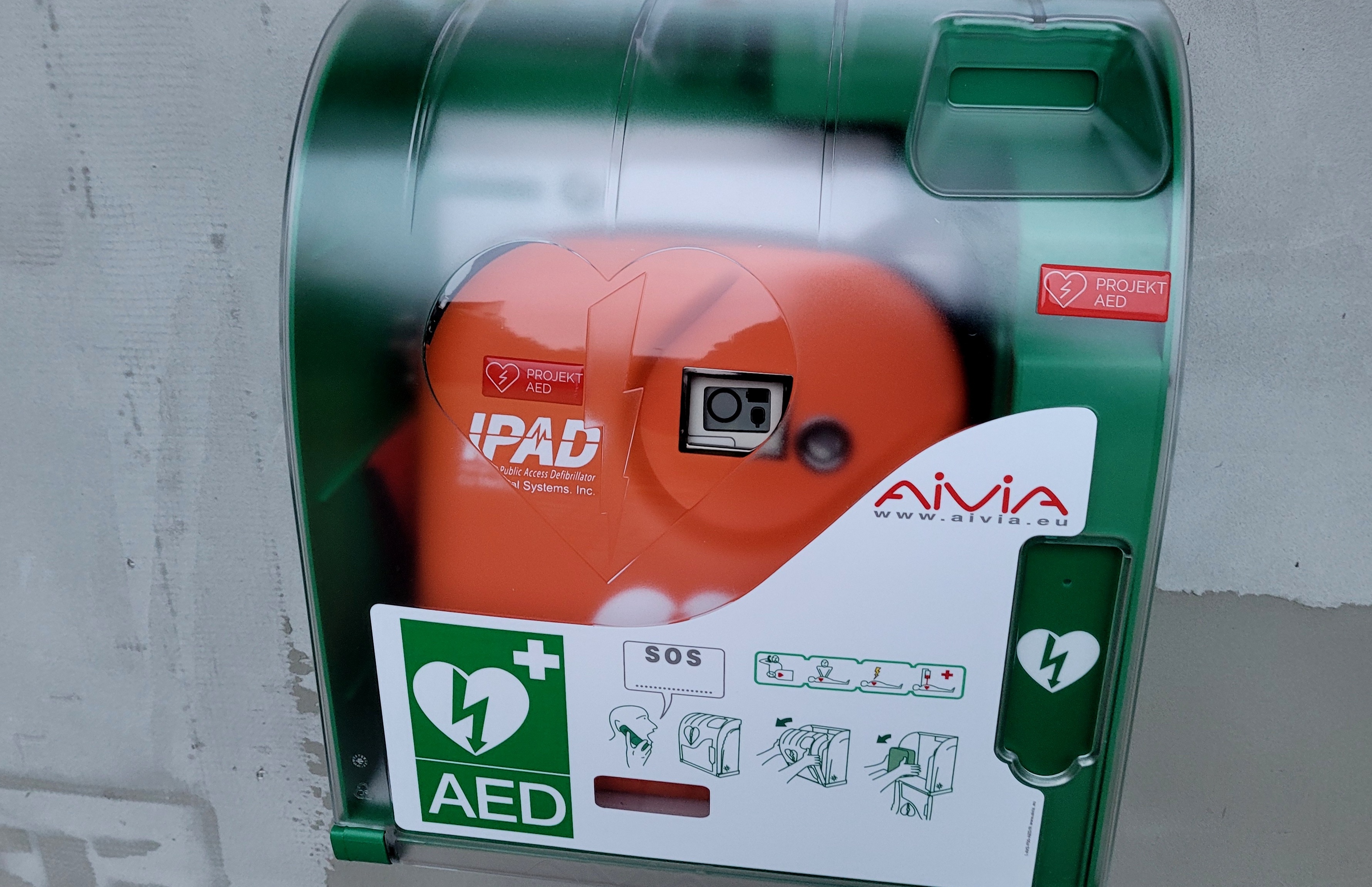 Defibrylator automatyczny AED w skrzynce zamontowany na ścianie budynku