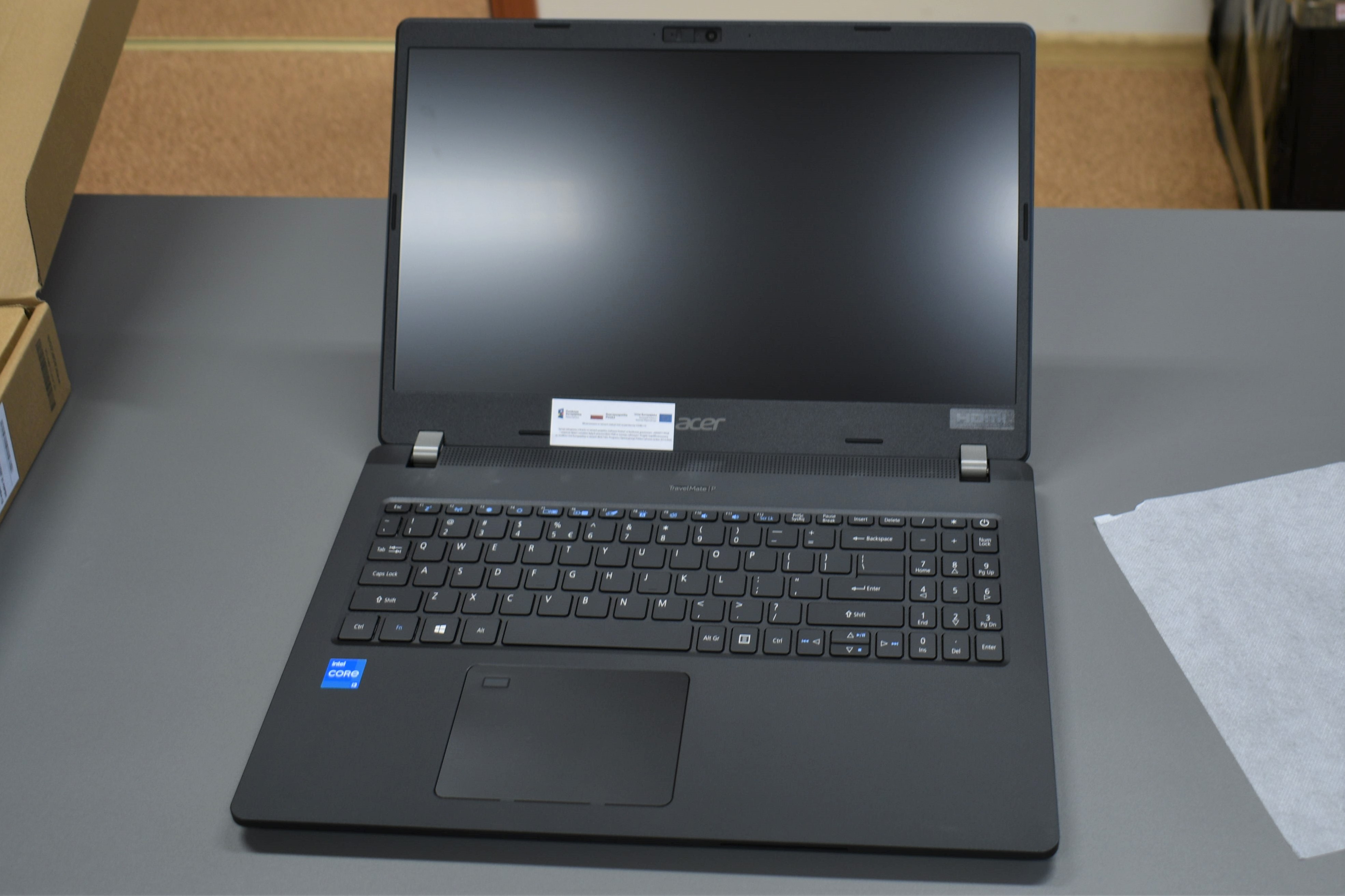 Na biurku ustawionym w&nbsp;zamkniętym pomiszczeniu stoi otwart laptop.