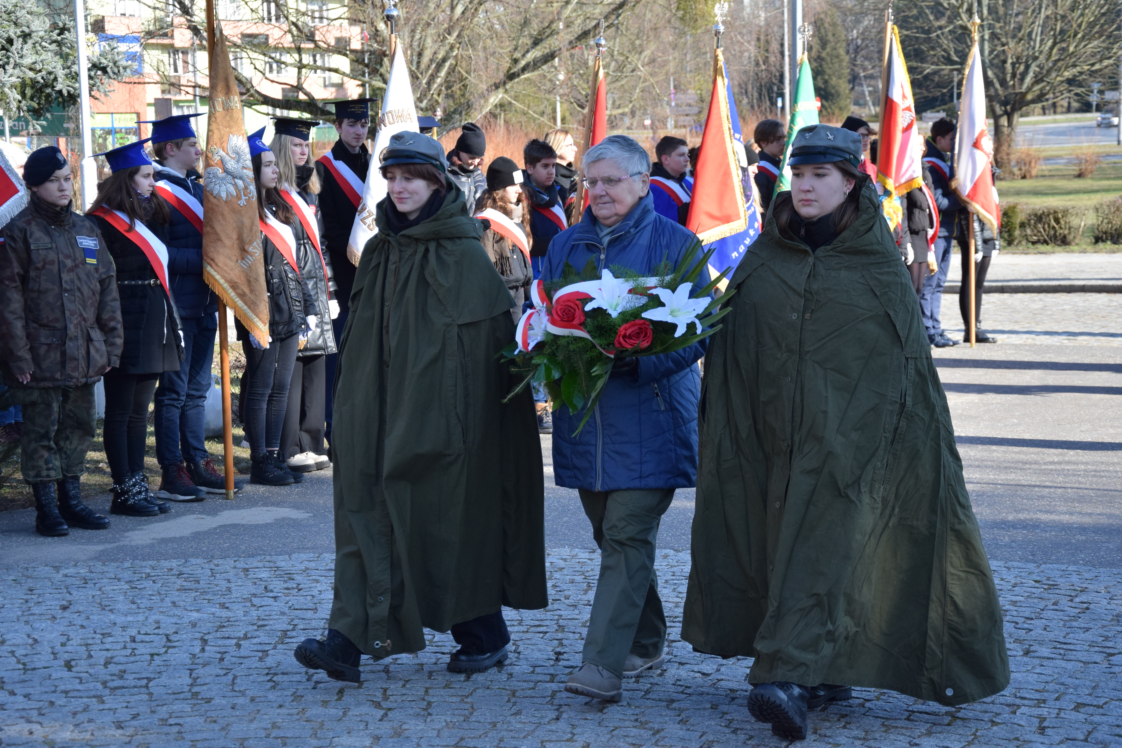 delegacja harcerzy (3 osoby) składa kwiaty pod pomnikiem