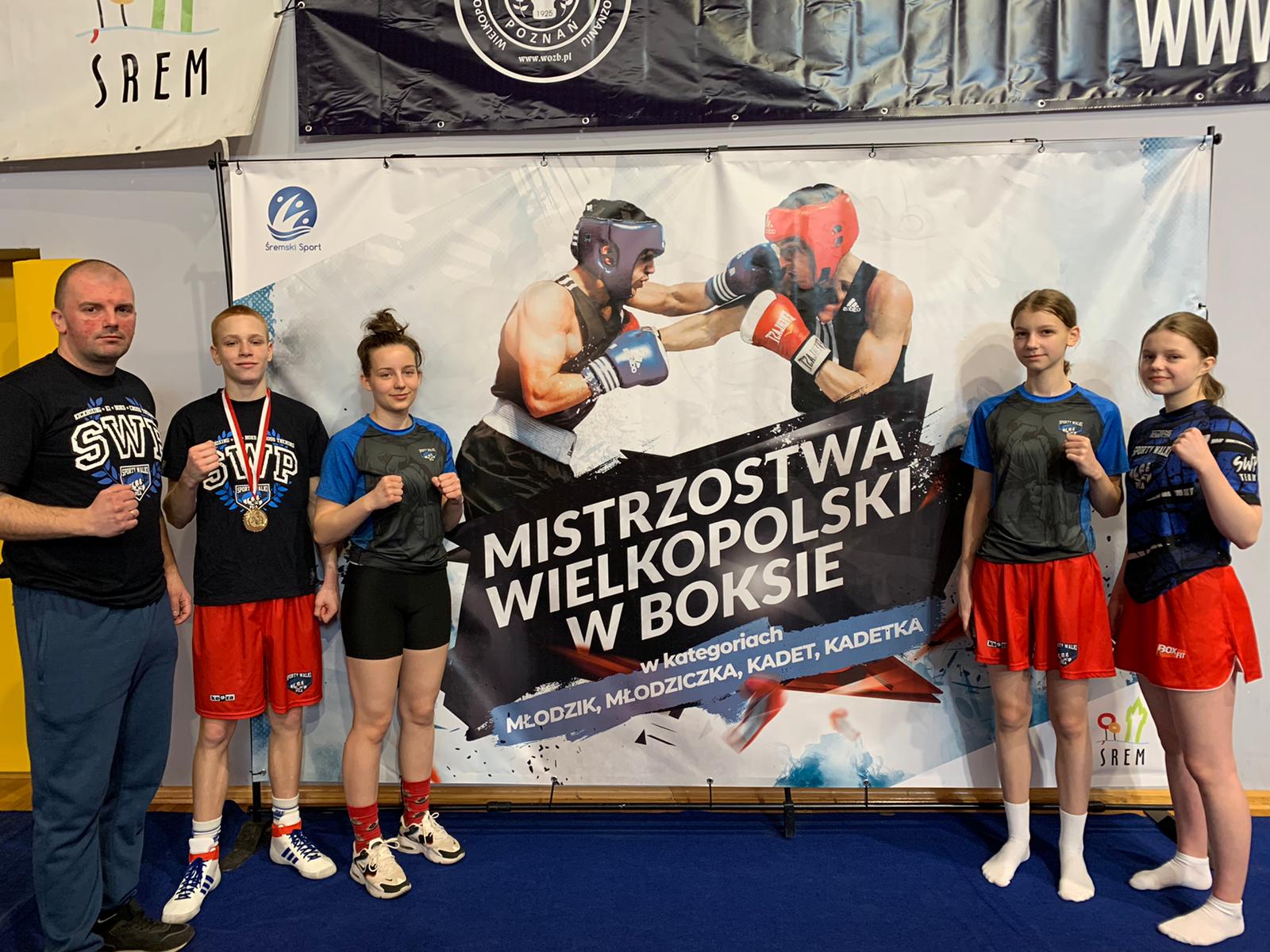Mistrzostwa Wielkopolski w Boksie Mistzostwa Wielkopolski w Boksie. Mężczyzna, chłopiec i trzy dziewczynki stoją i pozują zaciskając pięści.