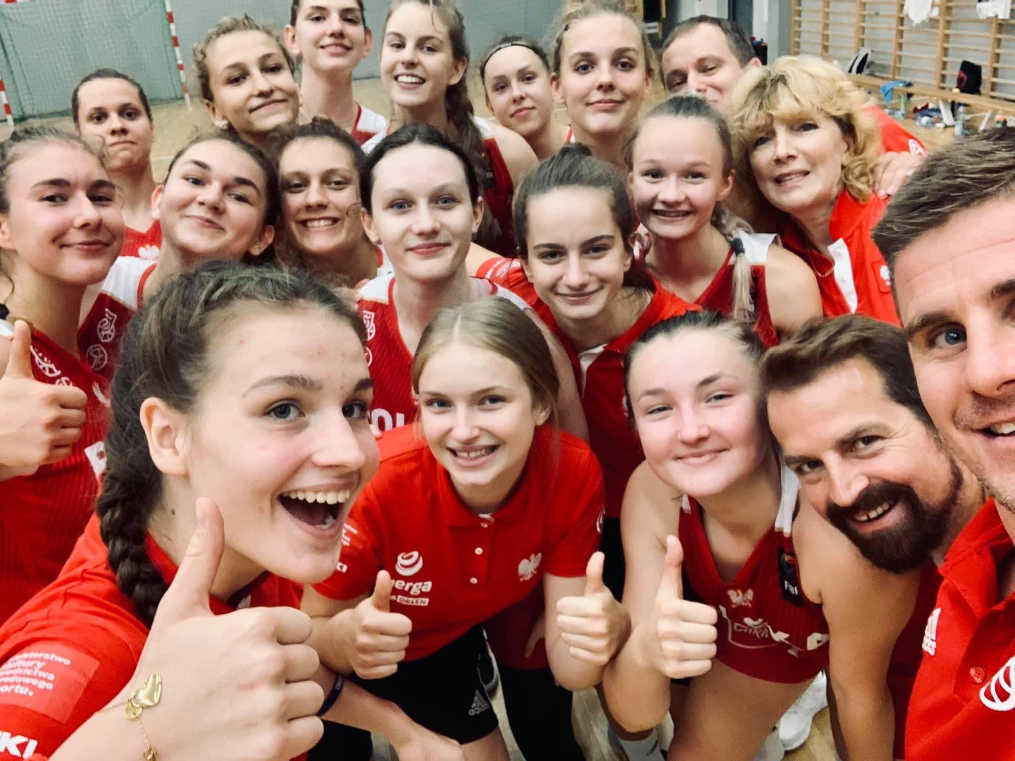 Wsparcie kolejnych klubów sportowych Grupa dziewczyn w strojach sportowych na hali sportowej robi selfie, wszystkie uśmiechają się do aparatu.