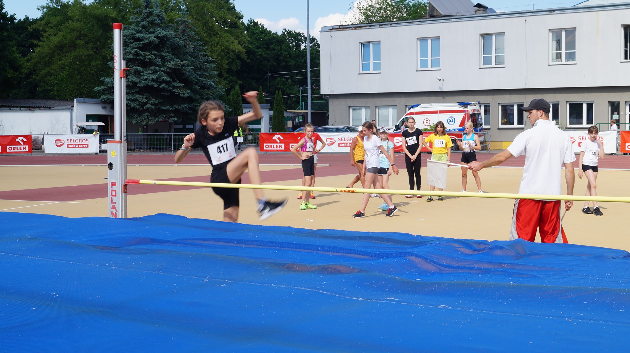 Zawody sportowe w skoku wzwyż. Skocznia, dziewczynki, mężczyzna.