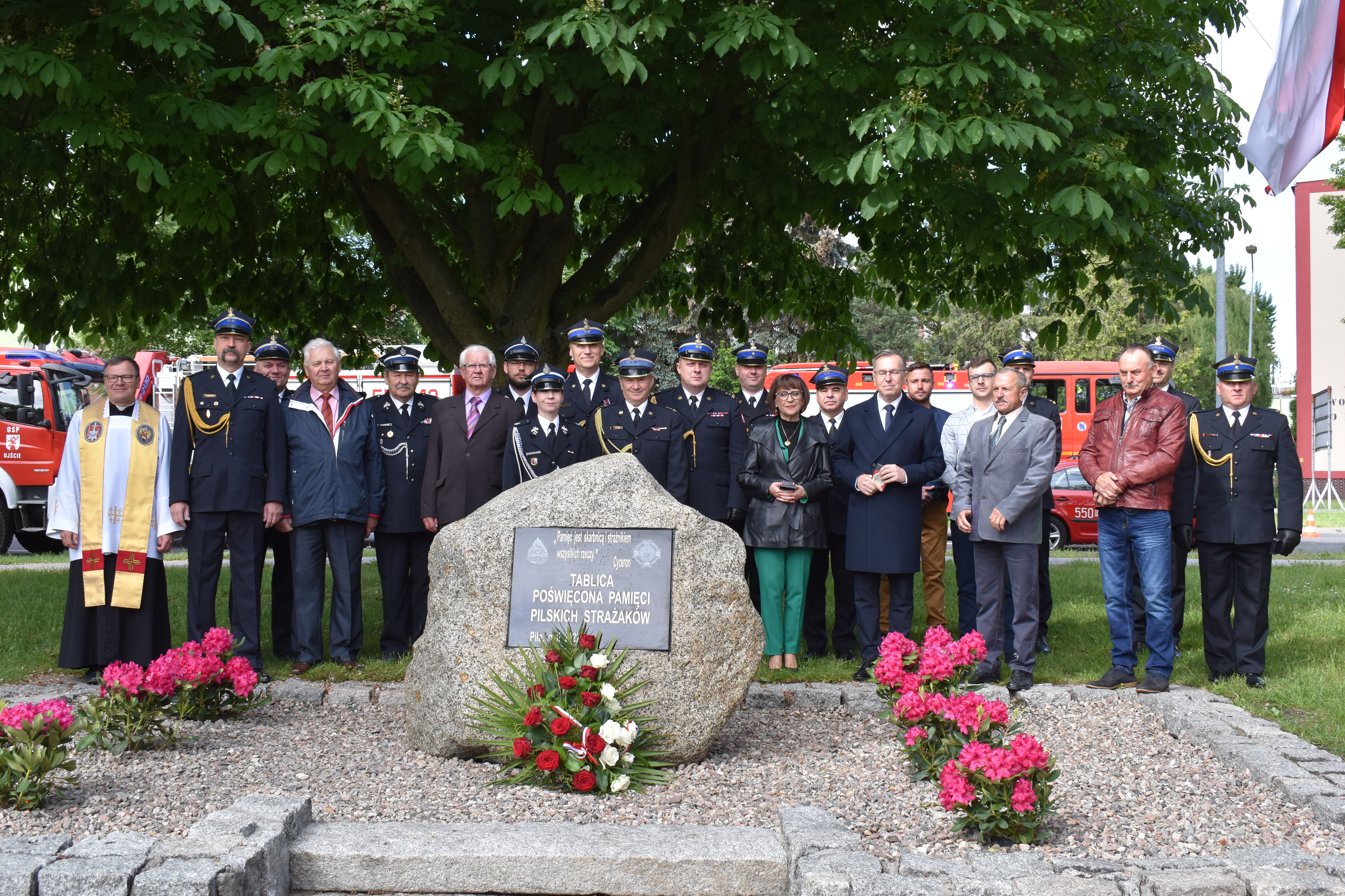 Odsłonięcie obelisku pamięci pilskich strażaków. Grupa ludzi. Cywiele, strażacy. Kobiety i mężczyźni. Obelisk i tablica pamiątkowa.
