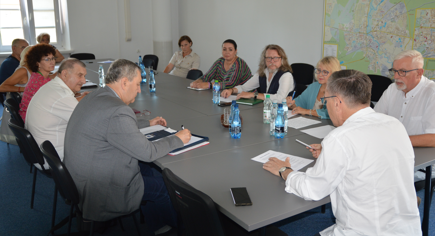 Spotkanie Pilskiej Rady Seniorów Grupa osób siedzi przy stole w sali konferencyjnej.