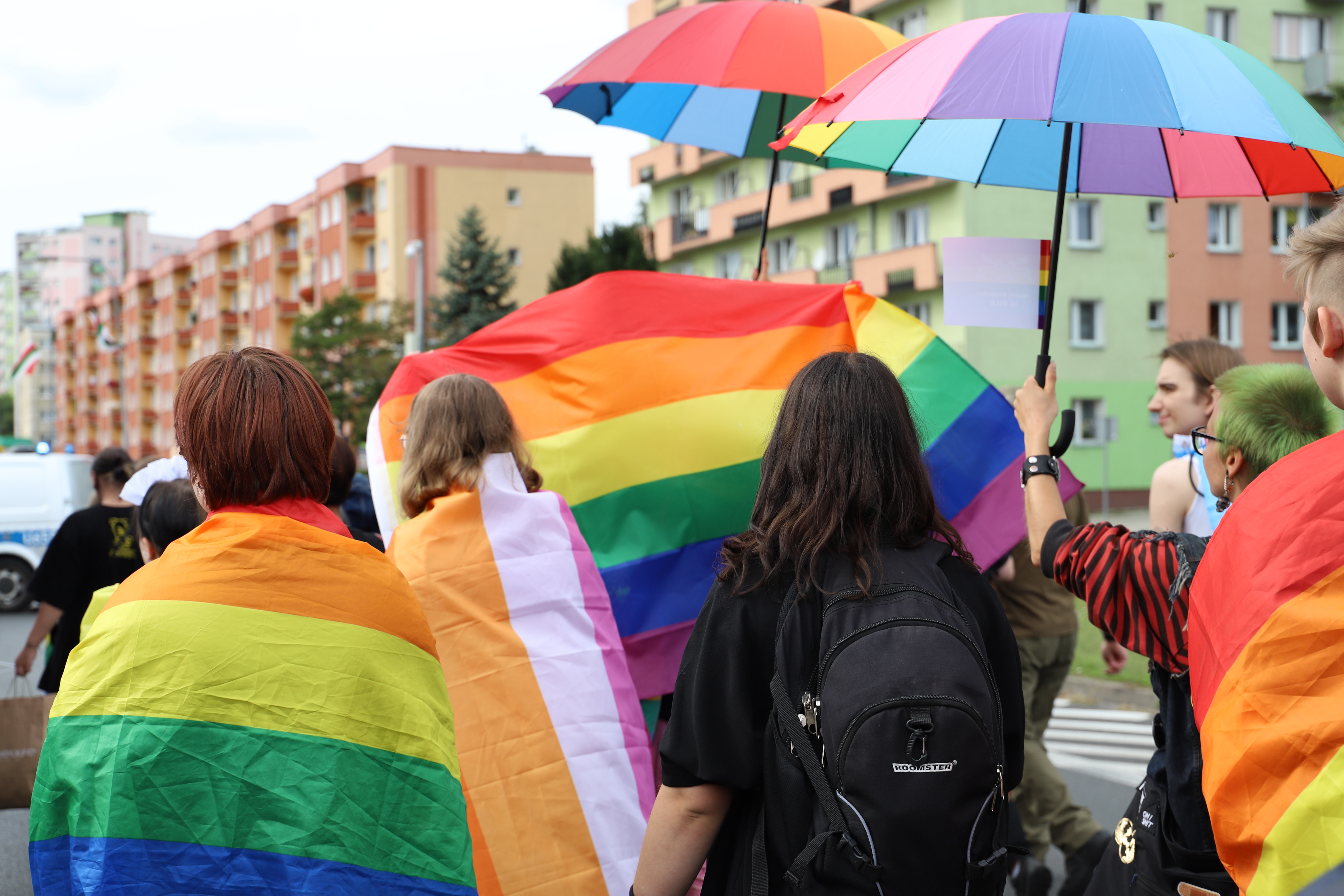 2. Marsz róności Ulica w mieście. Ulicą idzie manifestacja ludzi z tęczowymi flgami i akcesoriami.