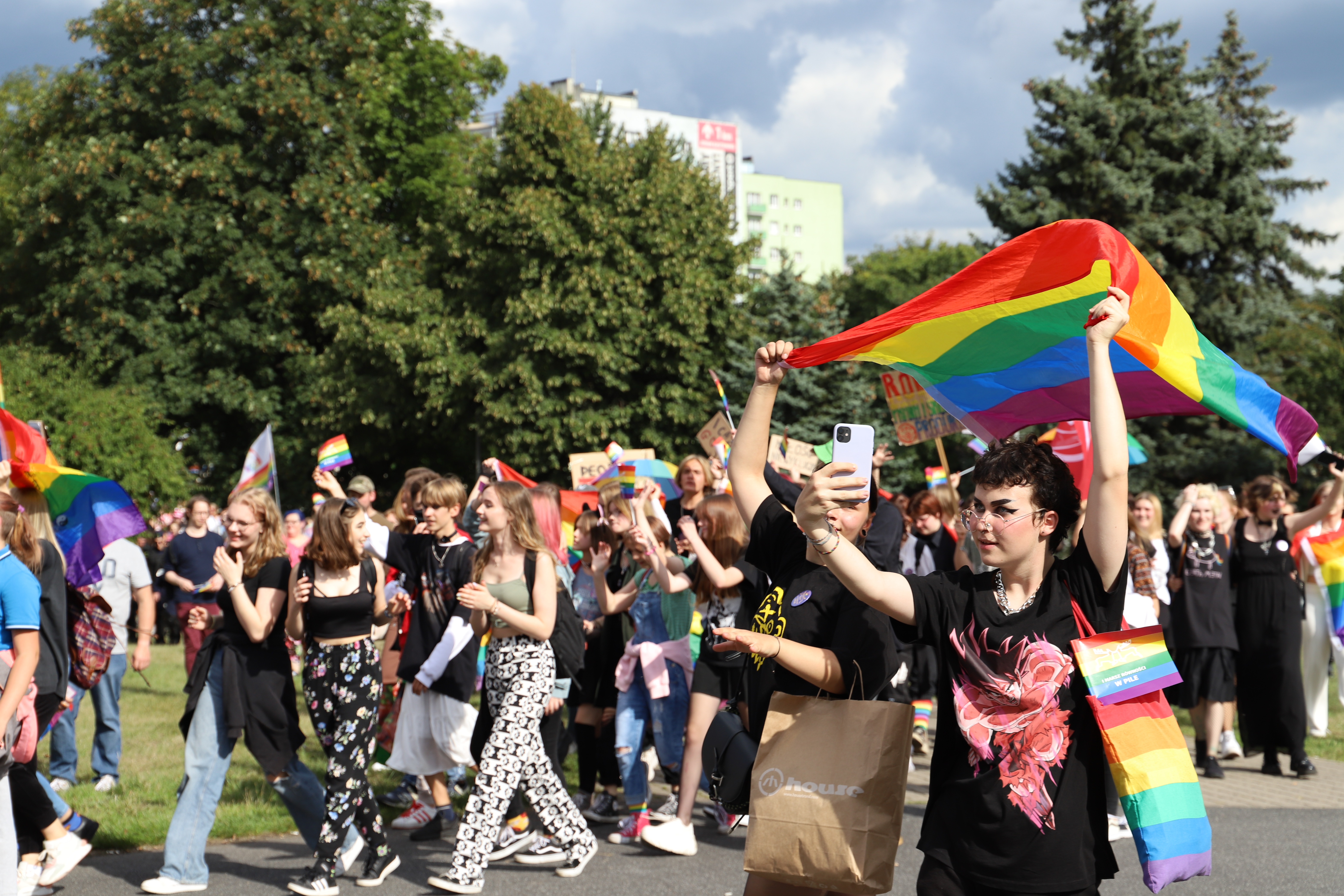 Plac w&nbsp;miesićie. manifestacja ludzi z&nbsp;tęczowymi flagami.