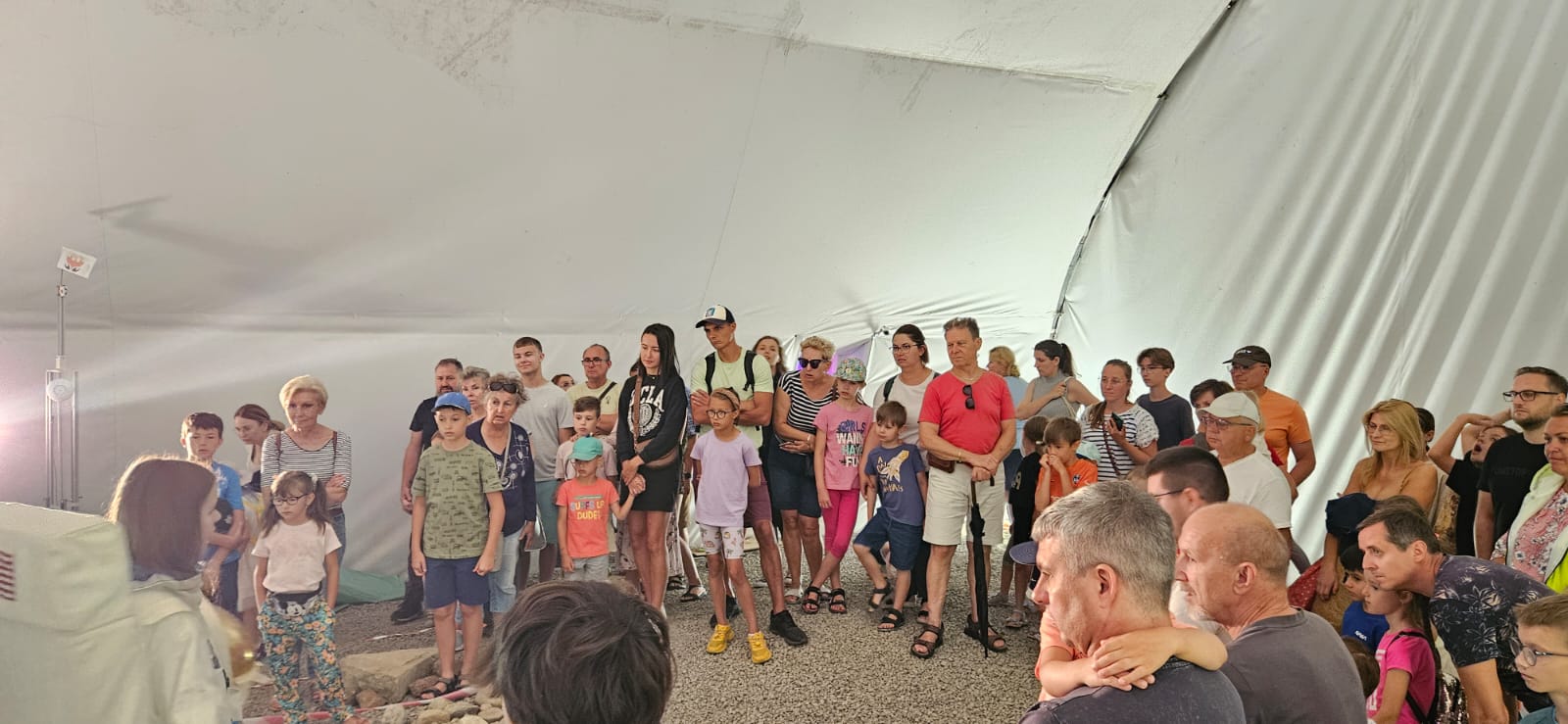 Grupa dorosłych i&nbsp;dzieci w&nbsp;namiocie, w&nbsp;kt&oacute;rym zasymulowano powierzchnię Księżyca 