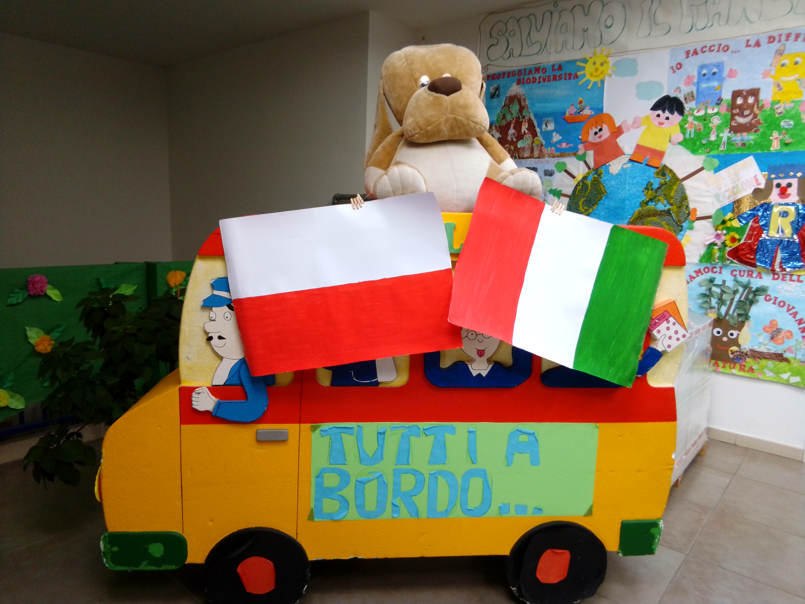 Wyjazdowe szkolenie w ramach projektu szkolenia kadry pedagogicznej Erasmus+ KA1 , tytuł projektu: „Samodzielnie Tworzę, Eksperymentuję, Myślę - akademia kompetencji przyszłości.” W pomieszczeniu stoi model wykonanego zz papieru przez dzieci autobusu. Autobus przewozi pluszowe zabawki i jest udekorowany polską i włoską flagą. Na karoserii autobusu widnieje te napis: "Tutti a bordo"