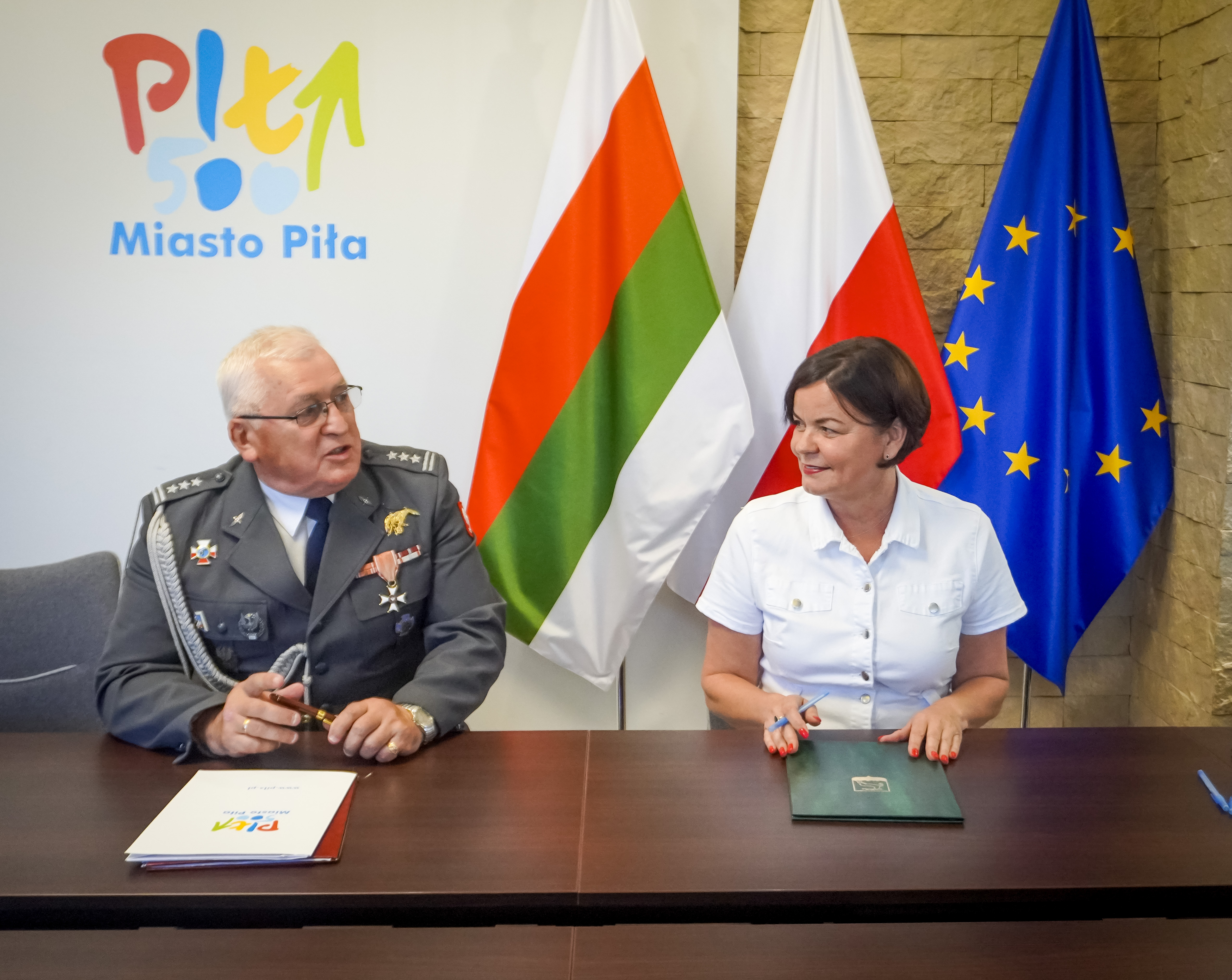 Kobieta i&nbsp;mężczyzna podpisują dokumenty.