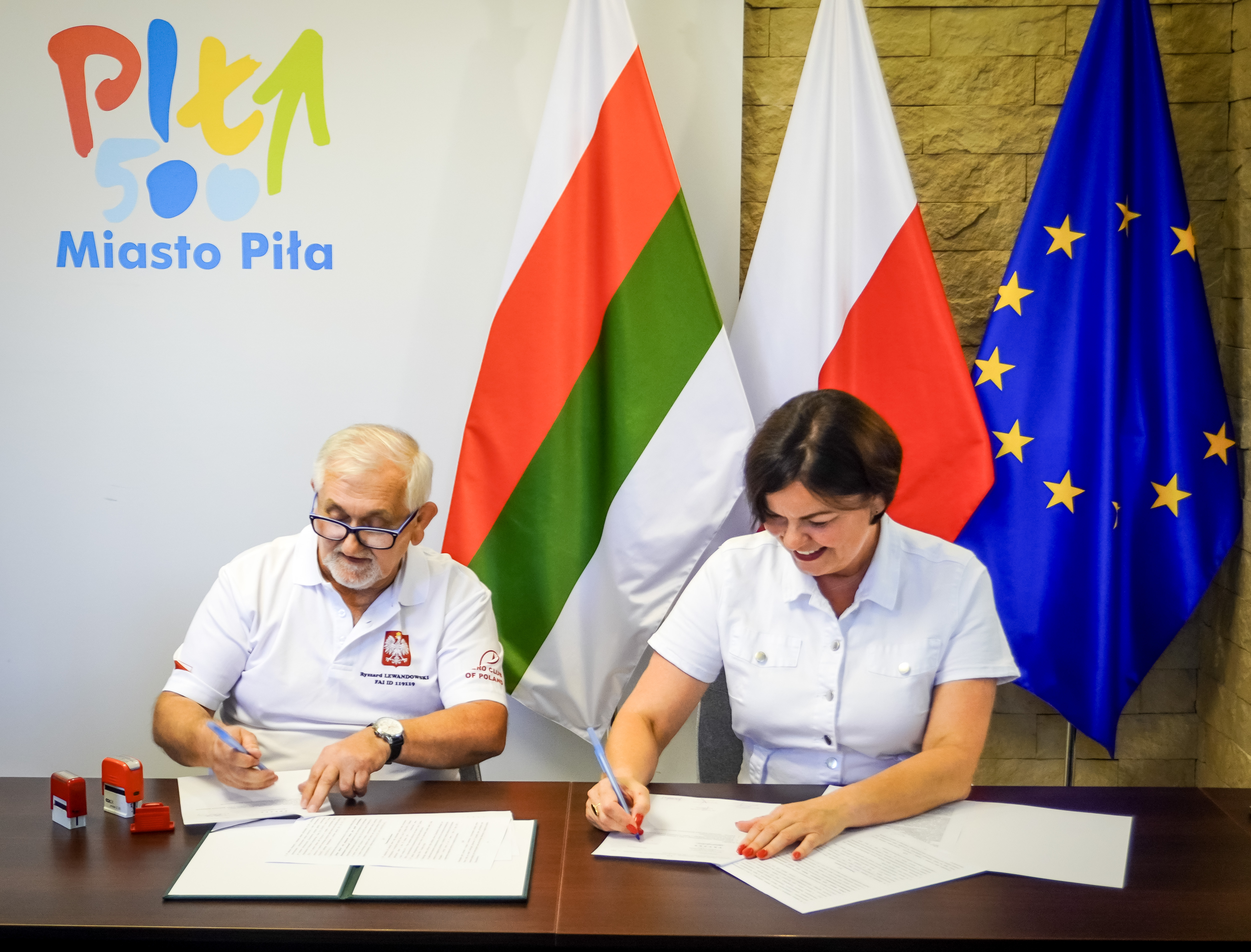 Kobieta i&nbsp;mężczyzna podpisują dokumenty.