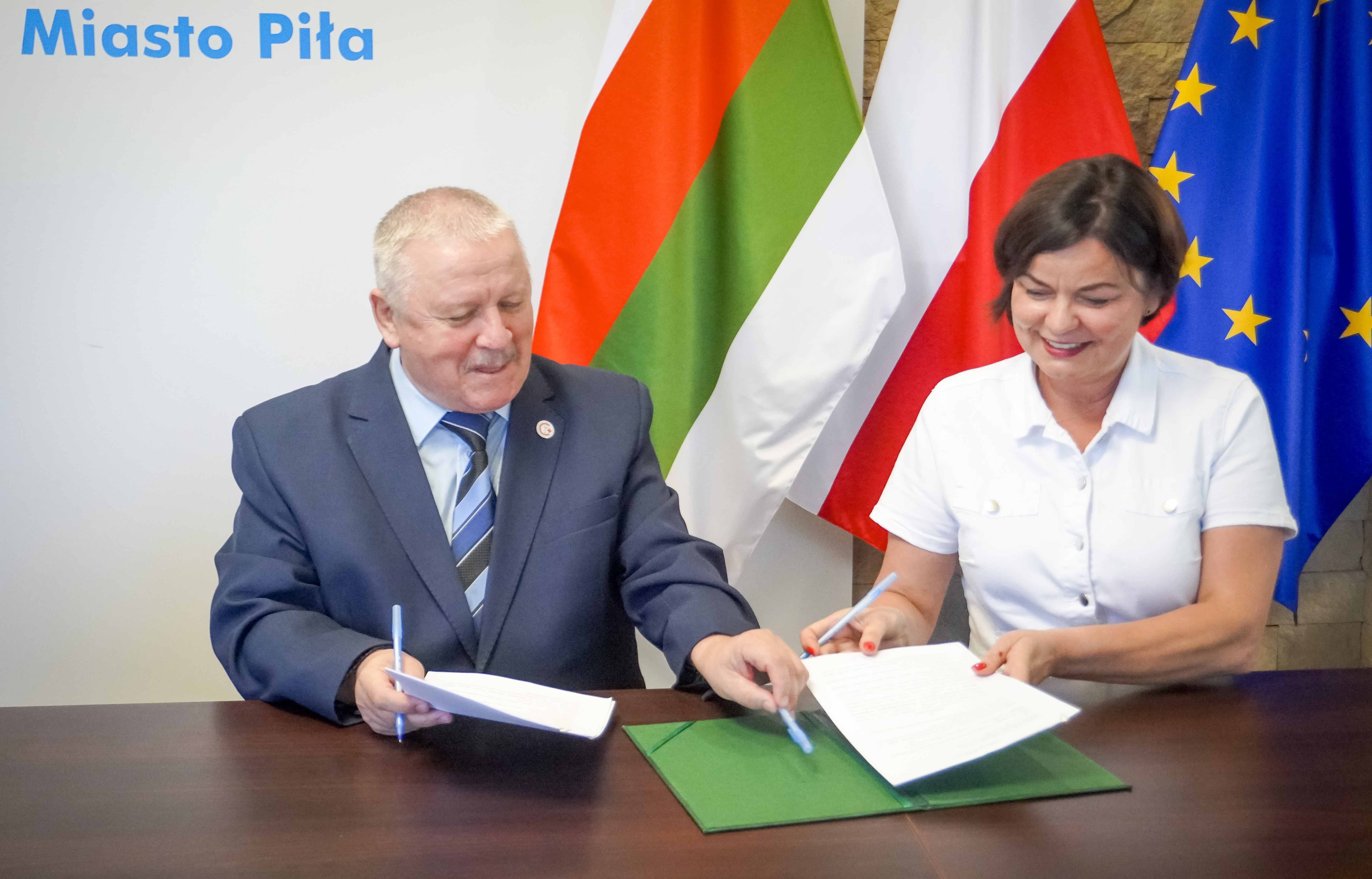 Kobieta i&nbsp;mężczyzna podpisują dokumenty.