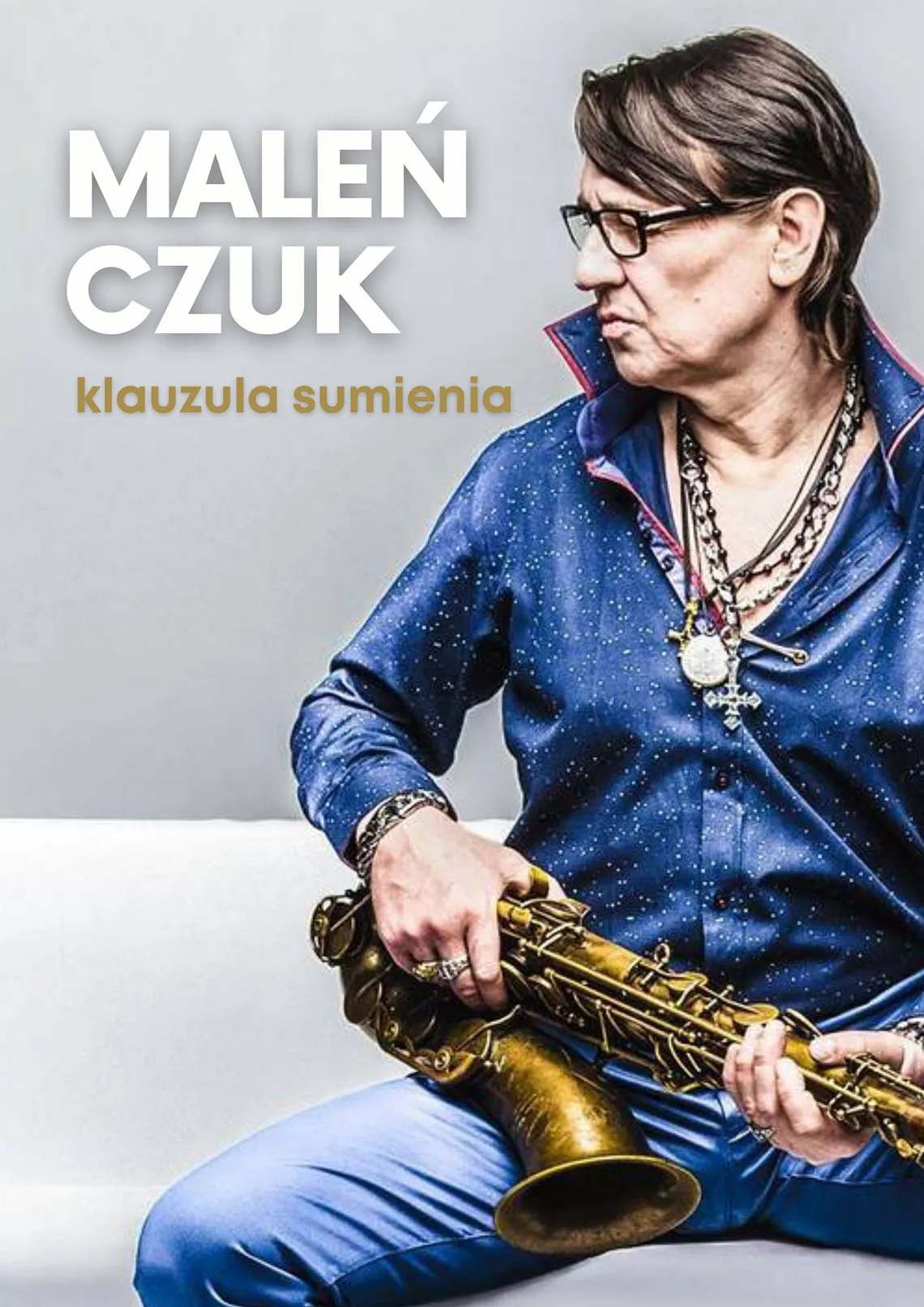 Maleńczuk Klauzula sumienia. Mężczyzna w niebieskiej koszuli, trzyma w rękach saksofon.