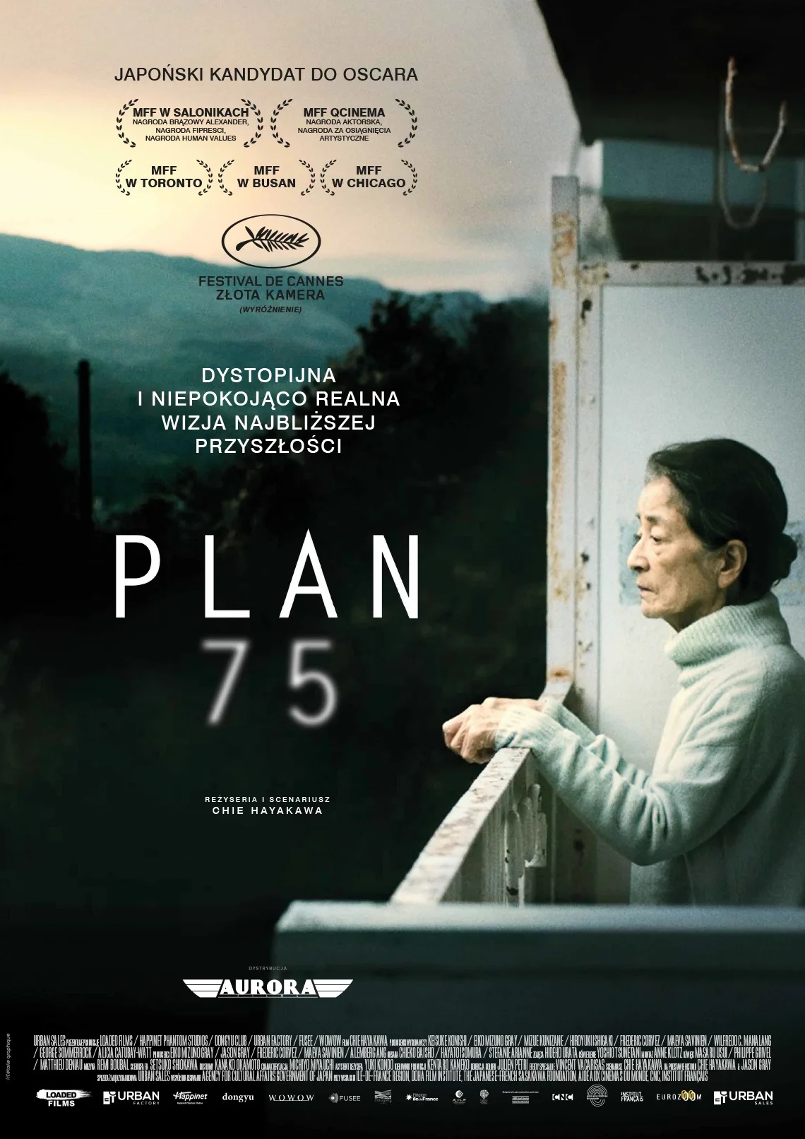 starsza kobieta - Azjatka, stoi na balkonie i spogląda przed siebie, w tle góry, napis: Plan 75, dystopijna niepokojąco realna wizja najbliższej przyszłości